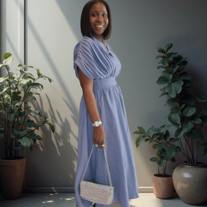 woman in blue linen dress with pleated bodice and defined waist, exuding effortless elegance
