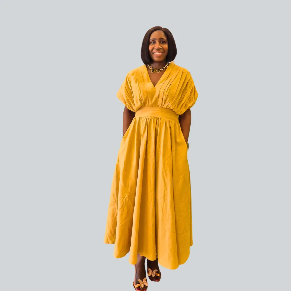 Front view of the TENIADE MACAULAY Cocoon Linen Dress in gold showing the architectural pleating and V-neckline.
