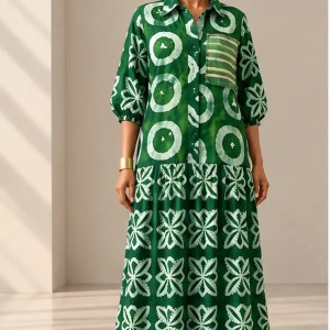Front view of Shade African Print Maxi Dress in green and white batik, featuring a button-down front, gathered sleeves and tiered skirt.