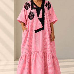 Model wearing the Ayo pink and white pinstripe linen bubu with black embroidery, wide sleeves and gathered hem.